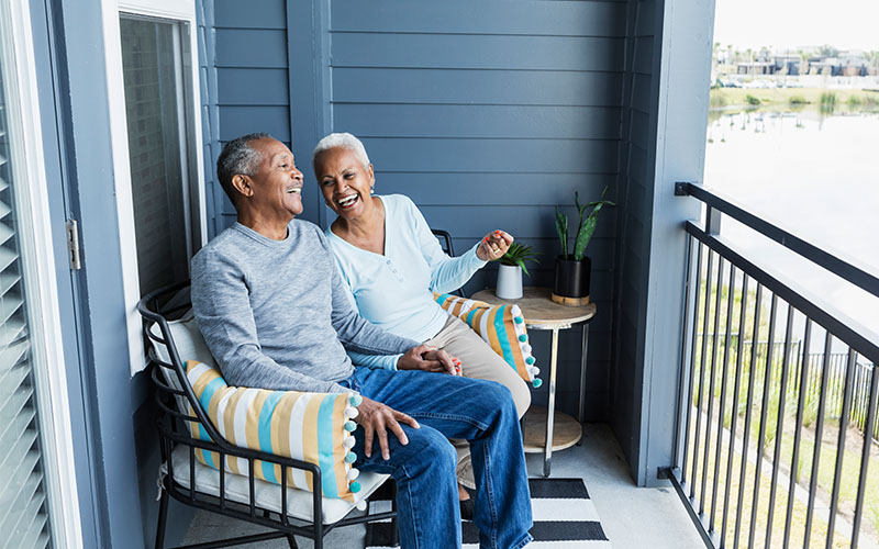 Two retirees sitting on their porch enjoying retirement