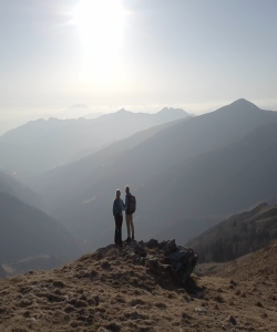 Couple standing on top of a mountain looking at the view