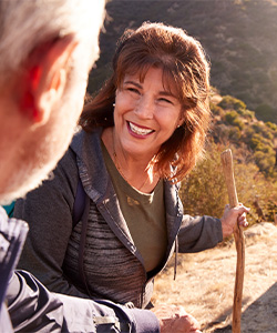 Retired woman smiling and hiking