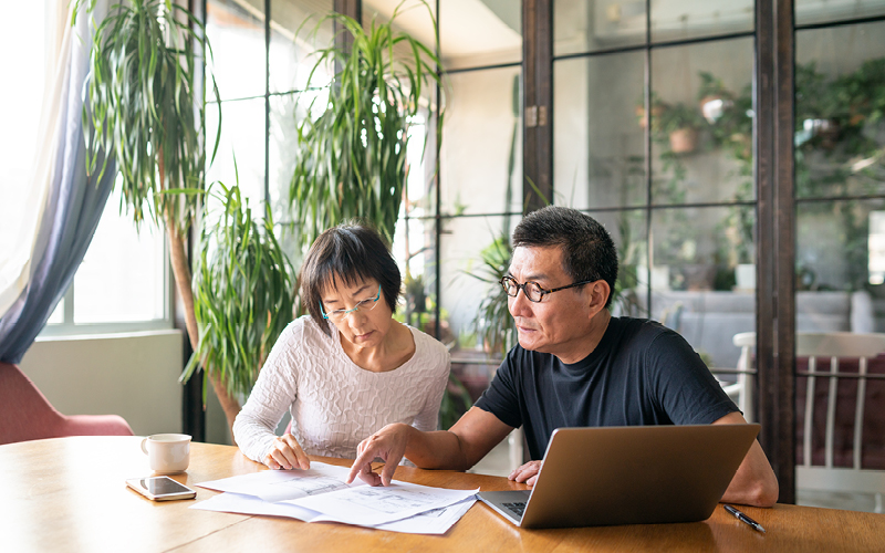 Two people looking at documents to plan their retiremen