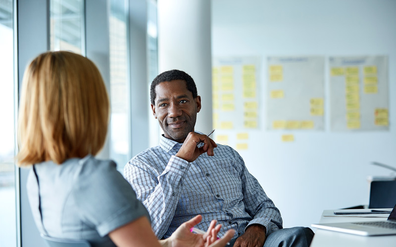 Man and woman in office discussing retirement