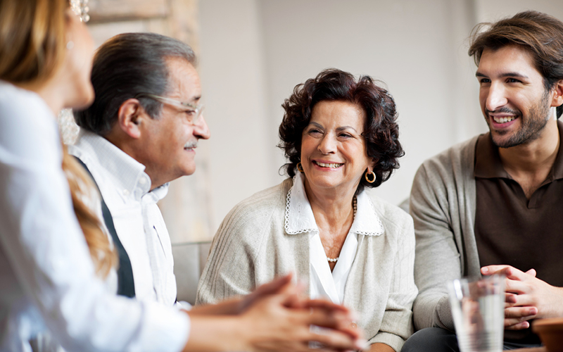 Family of four sitting around the table talking