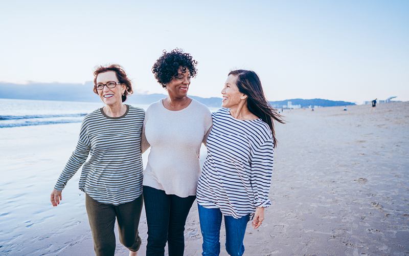 Three women walking on the beach together
